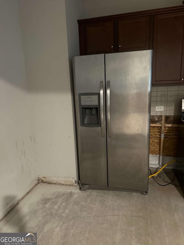 kitchen featuring decorative backsplash, stainless steel fridge, and dark brown cabinetry