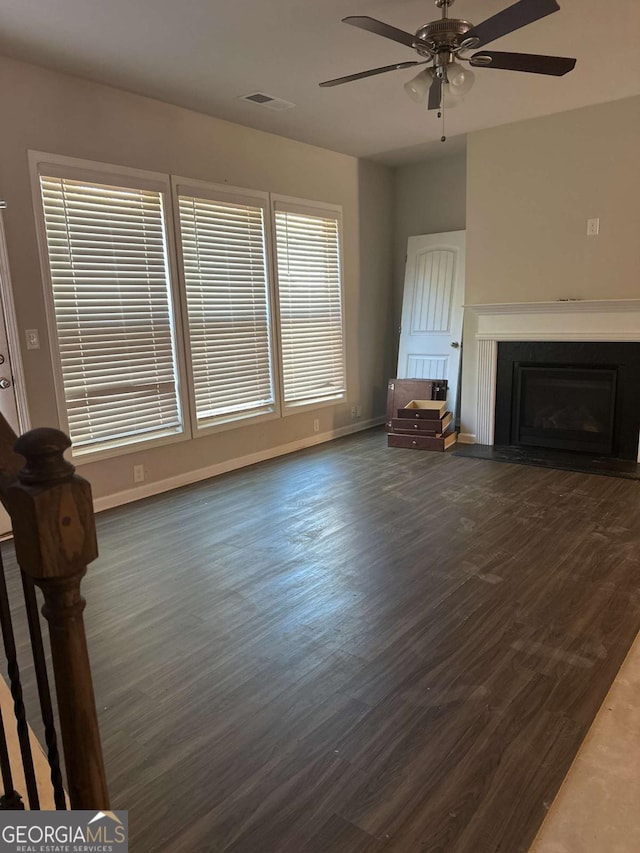 unfurnished living room with ceiling fan and dark wood-type flooring