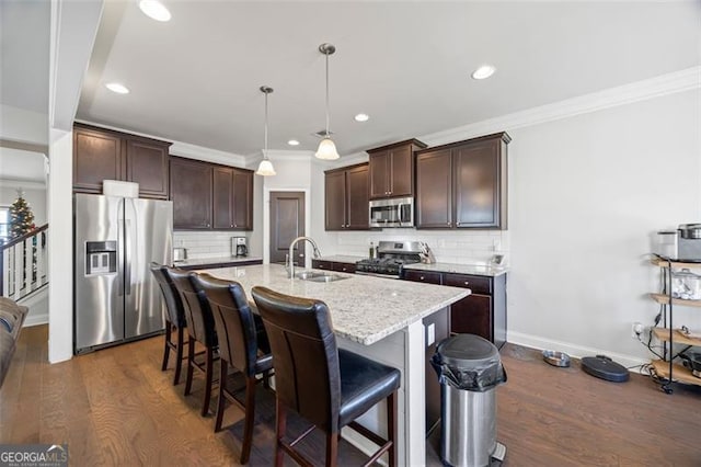 kitchen featuring decorative backsplash, appliances with stainless steel finishes, dark hardwood / wood-style flooring, sink, and pendant lighting