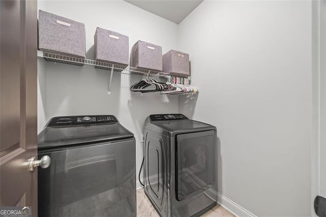 laundry room featuring laundry area, baseboards, and washer and clothes dryer