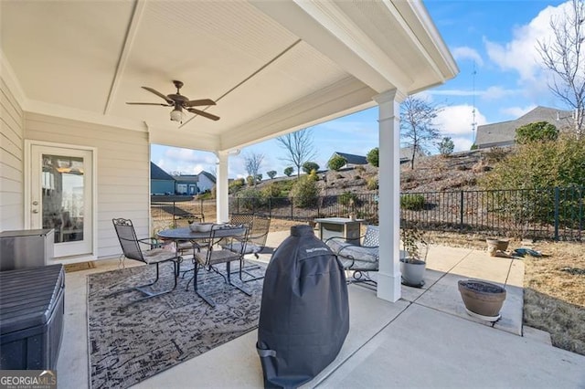 view of patio featuring fence, outdoor dining area, and a ceiling fan