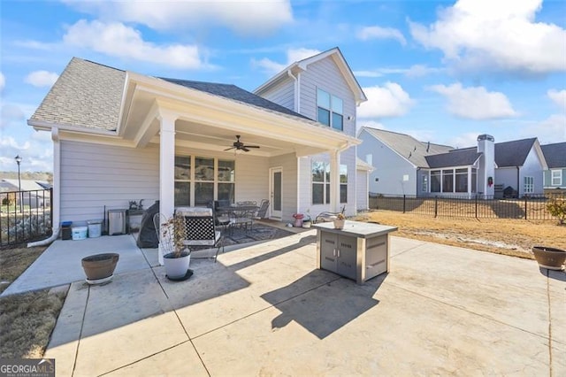 view of patio / terrace with ceiling fan, fence, and a fire pit