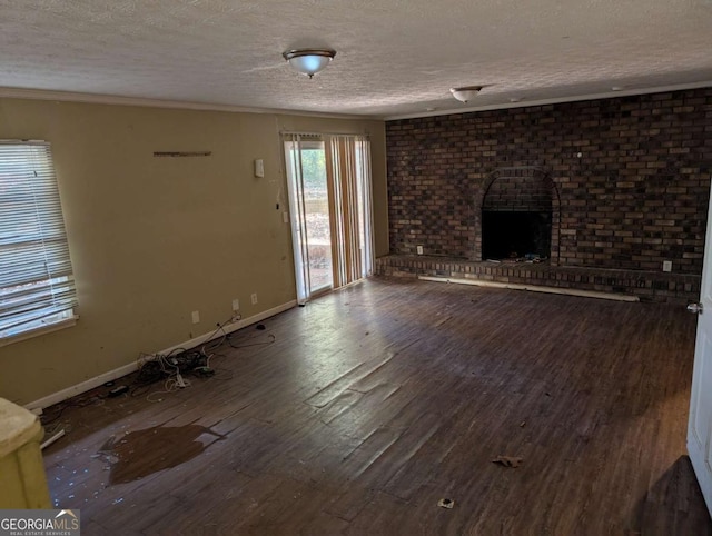 unfurnished living room with hardwood / wood-style floors, a fireplace, and a textured ceiling