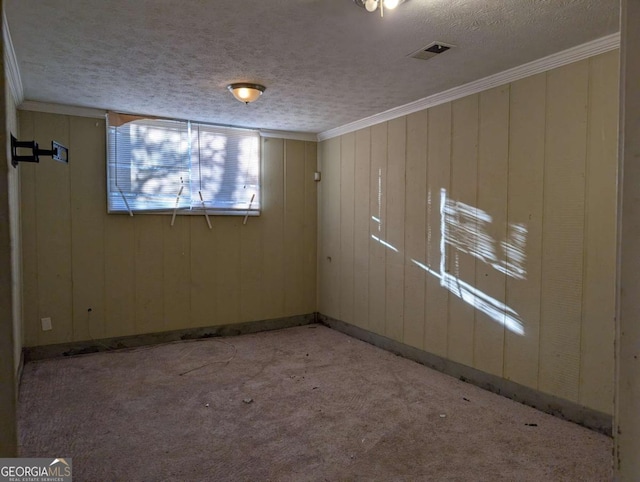 spare room featuring light carpet, a textured ceiling, and ornamental molding