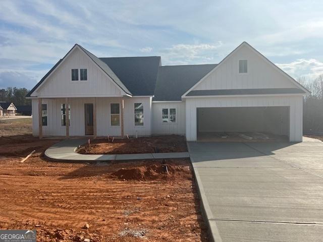 modern farmhouse featuring a garage and a porch