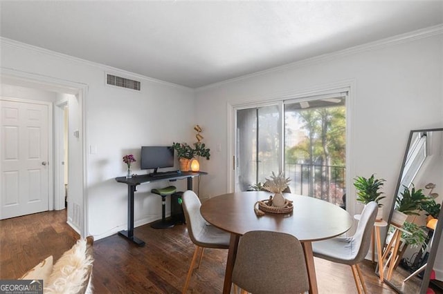 dining area with ornamental molding and dark wood-type flooring