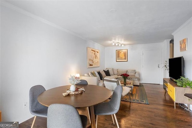 dining area featuring dark hardwood / wood-style floors and crown molding