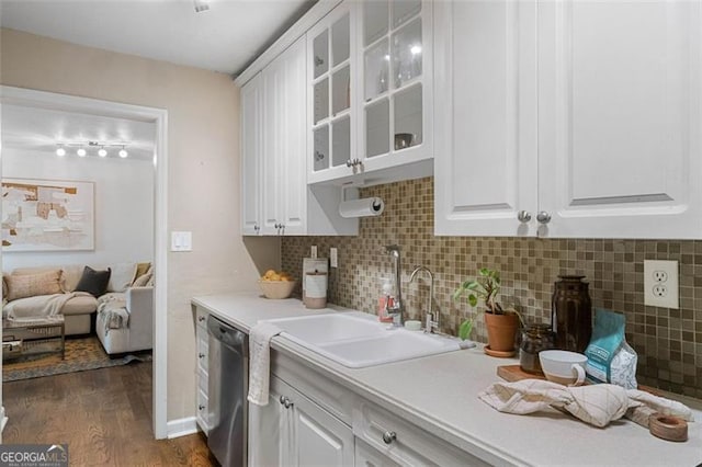 kitchen featuring dishwasher, sink, dark hardwood / wood-style floors, tasteful backsplash, and white cabinetry