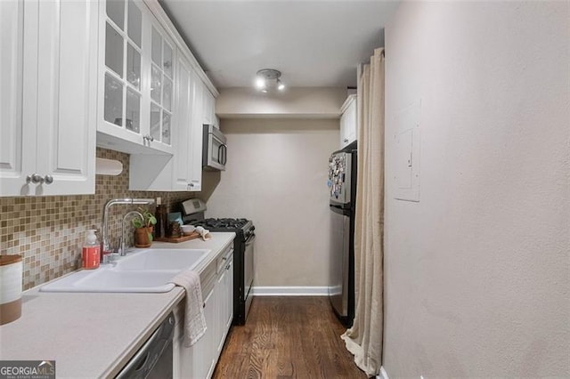 kitchen featuring tasteful backsplash, white cabinets, dark wood-type flooring, and appliances with stainless steel finishes