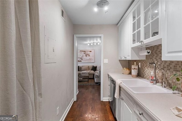 kitchen featuring dishwasher, sink, tasteful backsplash, dark hardwood / wood-style floors, and white cabinets