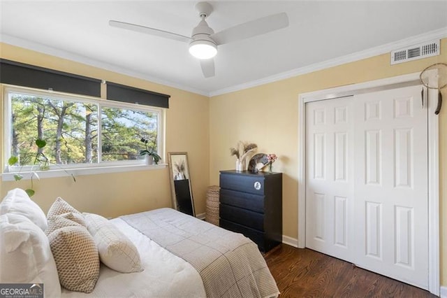 bedroom featuring ceiling fan, dark hardwood / wood-style floors, ornamental molding, and a closet