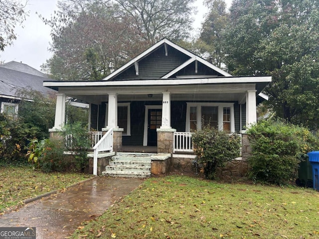 view of front of house featuring covered porch and a front lawn