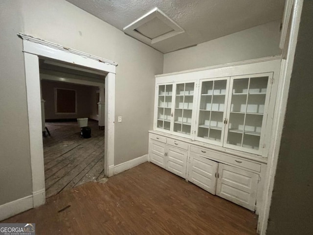 corridor featuring a textured ceiling and dark wood-type flooring