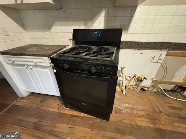 kitchen with backsplash, white cabinetry, black gas range oven, and dark wood-type flooring