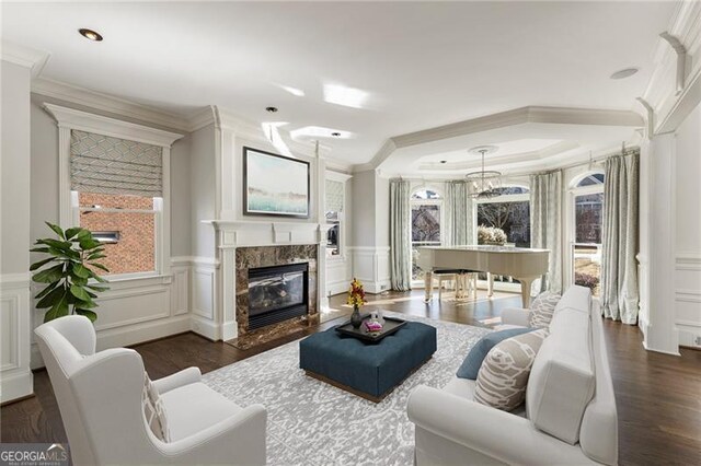 living room featuring a fireplace, dark wood-type flooring, and ornamental molding