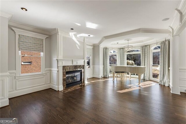 unfurnished living room featuring a fireplace, crown molding, and dark wood-type flooring