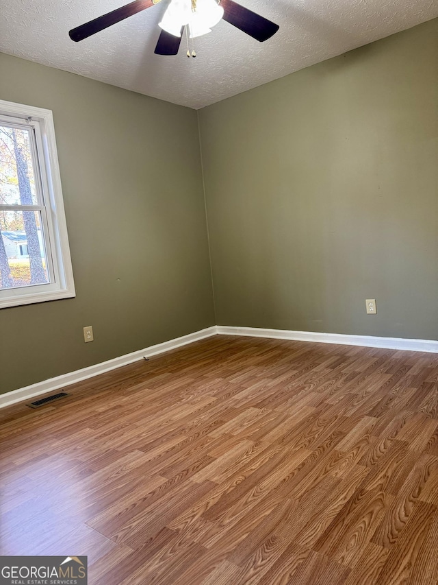 spare room with wood-type flooring, a textured ceiling, and ceiling fan