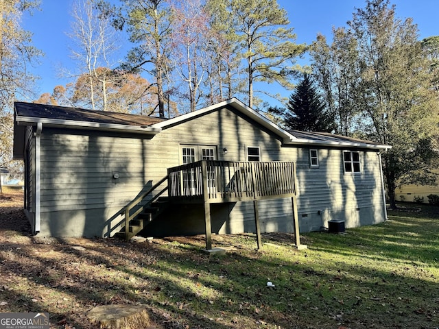 rear view of house featuring a yard and a wooden deck