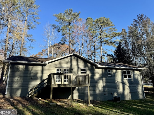 back of property featuring a deck and a lawn