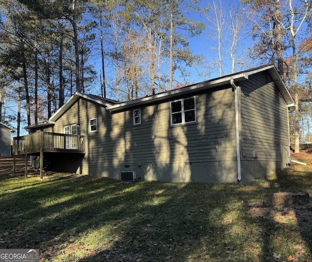 view of side of home featuring a wooden deck, a yard, and cooling unit