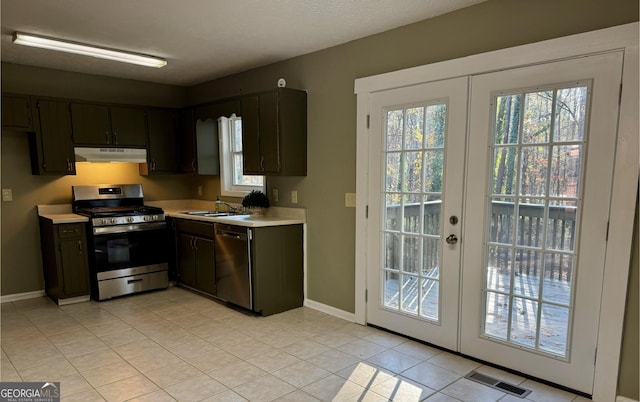 kitchen featuring sink, french doors, dark brown cabinets, light tile patterned floors, and appliances with stainless steel finishes