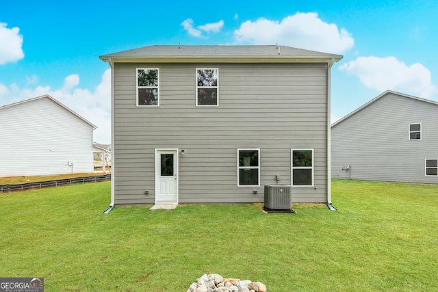 rear view of property featuring a yard and central AC