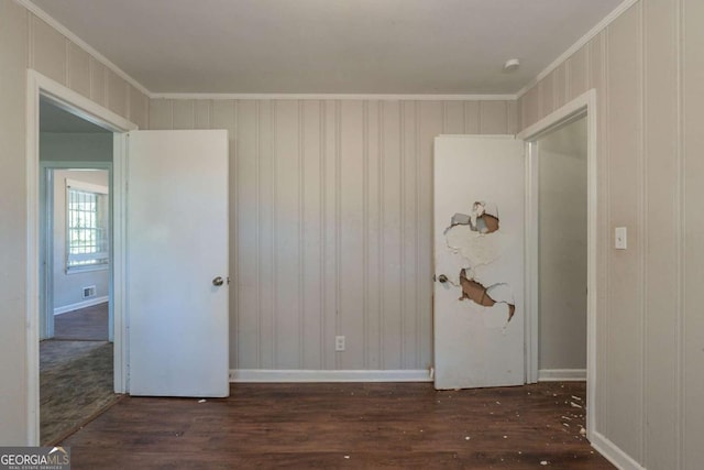 unfurnished room with ornamental molding and dark wood-type flooring