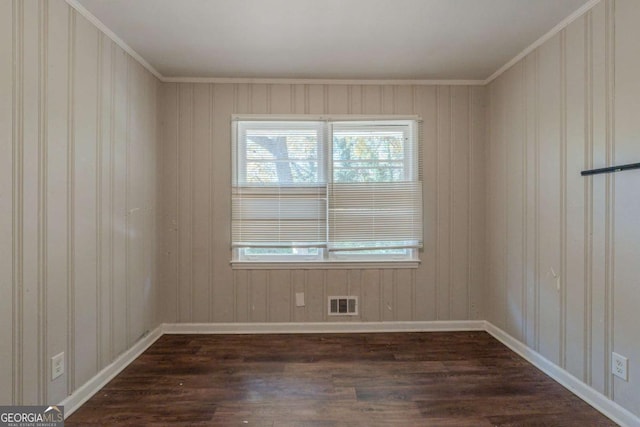 spare room featuring dark wood-type flooring and ornamental molding