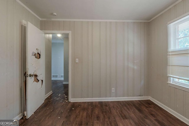 spare room with crown molding and dark wood-type flooring