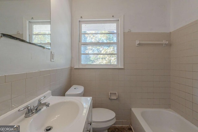 bathroom featuring a healthy amount of sunlight, toilet, and tile walls