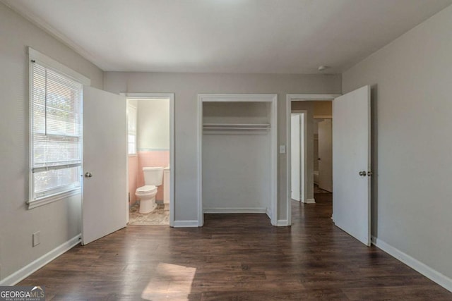 unfurnished bedroom with ensuite bath and dark hardwood / wood-style flooring