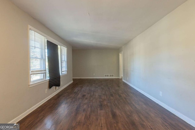 spare room with dark wood-type flooring