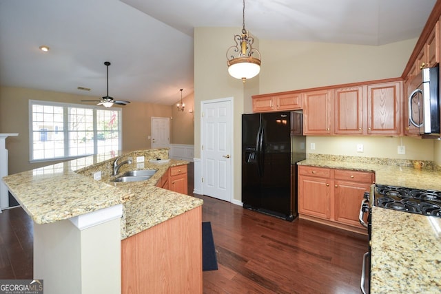 kitchen with black fridge, a sink, stainless steel microwave, dark wood finished floors, and gas range oven