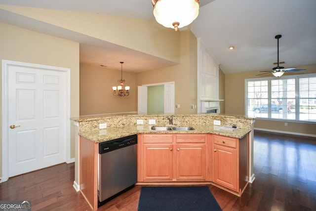 kitchen featuring dark wood finished floors, vaulted ceiling, light stone counters, stainless steel dishwasher, and a sink