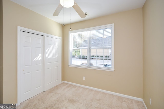 unfurnished bedroom with a ceiling fan, carpet flooring, baseboards, and a closet