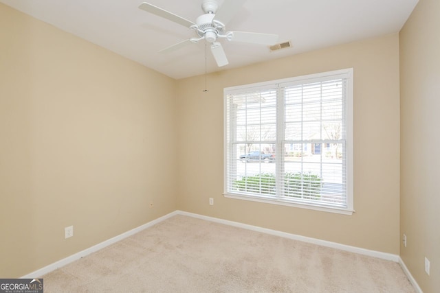 unfurnished room featuring visible vents, carpet floors, baseboards, and ceiling fan