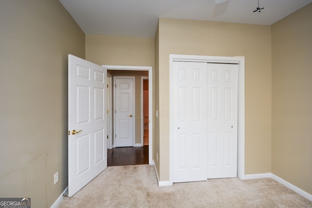 unfurnished bedroom with a closet, carpet flooring, and baseboards