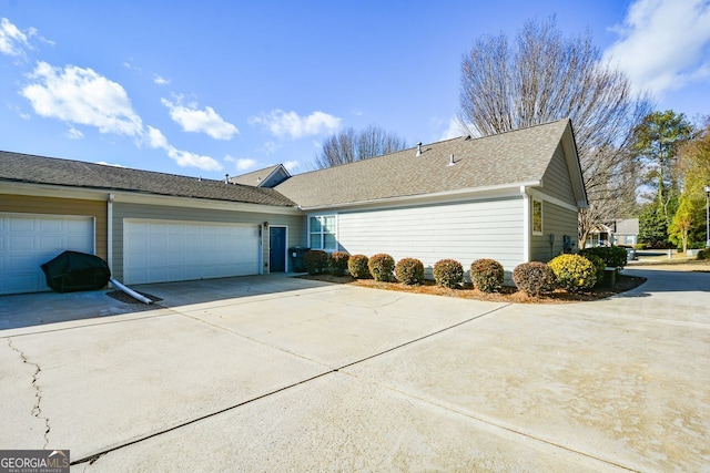 view of side of property featuring a garage and driveway