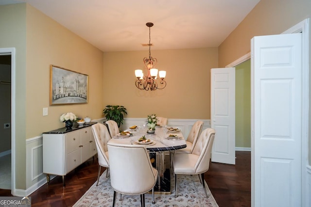 dining room featuring a notable chandelier, a decorative wall, and a wainscoted wall