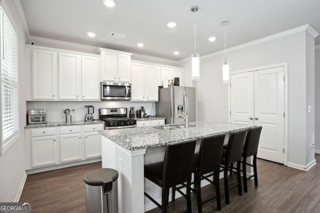 kitchen featuring light stone countertops, stainless steel appliances, sink, a center island with sink, and white cabinetry