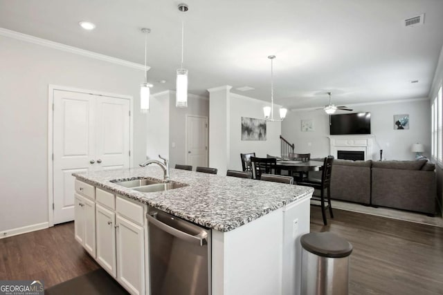 kitchen with sink, white cabinetry, stainless steel dishwasher, and an island with sink