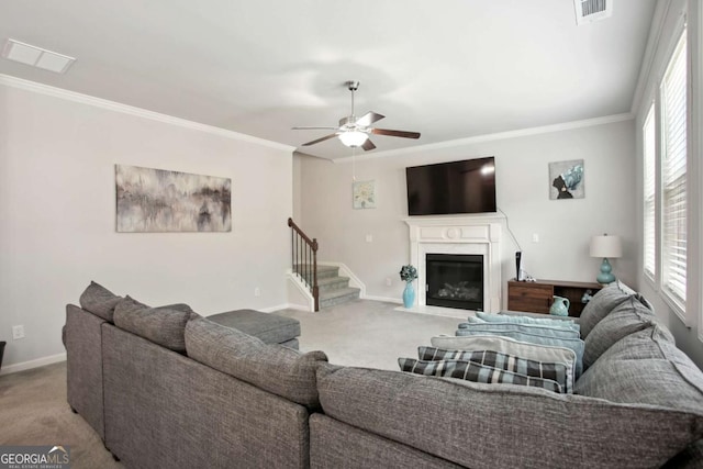 living room with crown molding, ceiling fan, and light carpet