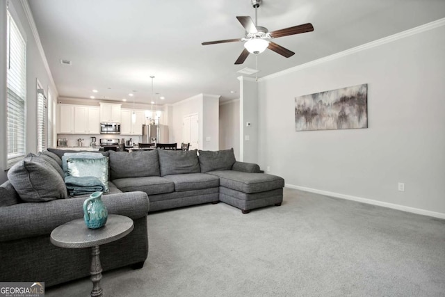 carpeted living room featuring ceiling fan and ornamental molding