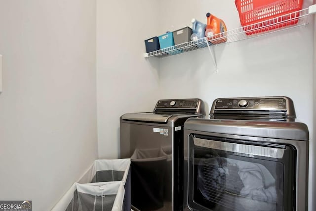 clothes washing area with washer and clothes dryer