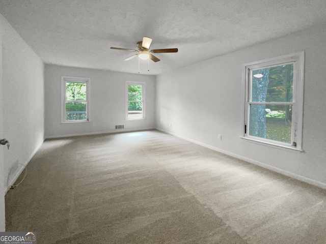 unfurnished room featuring ceiling fan, carpet, and a textured ceiling