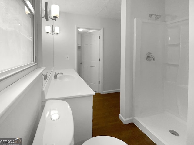 bathroom with vanity, wood-type flooring, a textured ceiling, and walk in shower