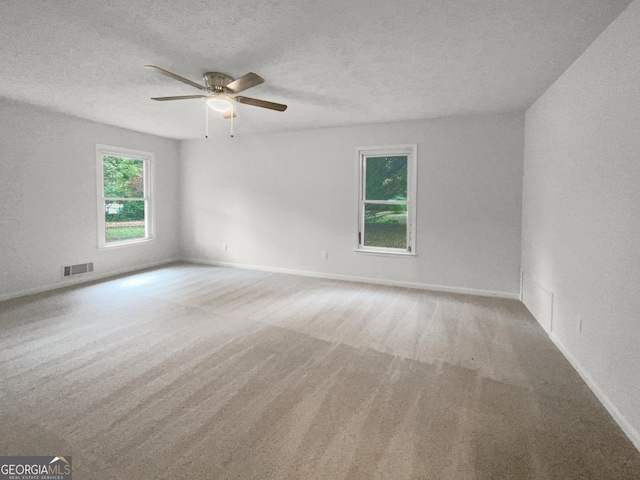 carpeted empty room with a textured ceiling and ceiling fan