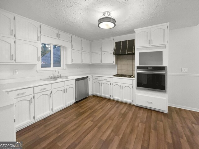 kitchen with white cabinets, sink, dark hardwood / wood-style flooring, stainless steel appliances, and extractor fan