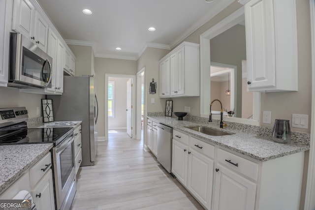 kitchen featuring light stone countertops, stainless steel appliances, sink, light hardwood / wood-style floors, and white cabinetry