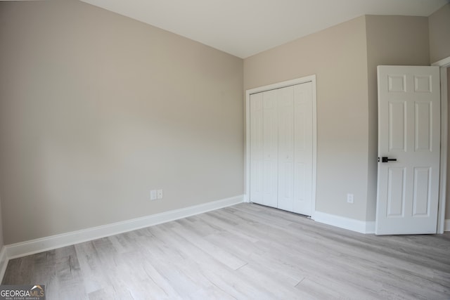 unfurnished bedroom featuring light hardwood / wood-style floors and a closet